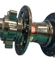 A metal bicycle hub component with a black multi-sprocket rear wheel side and a polished silver front spindle.