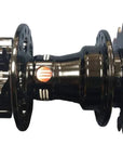 A used black bicycle hub with a small orange and white logo.