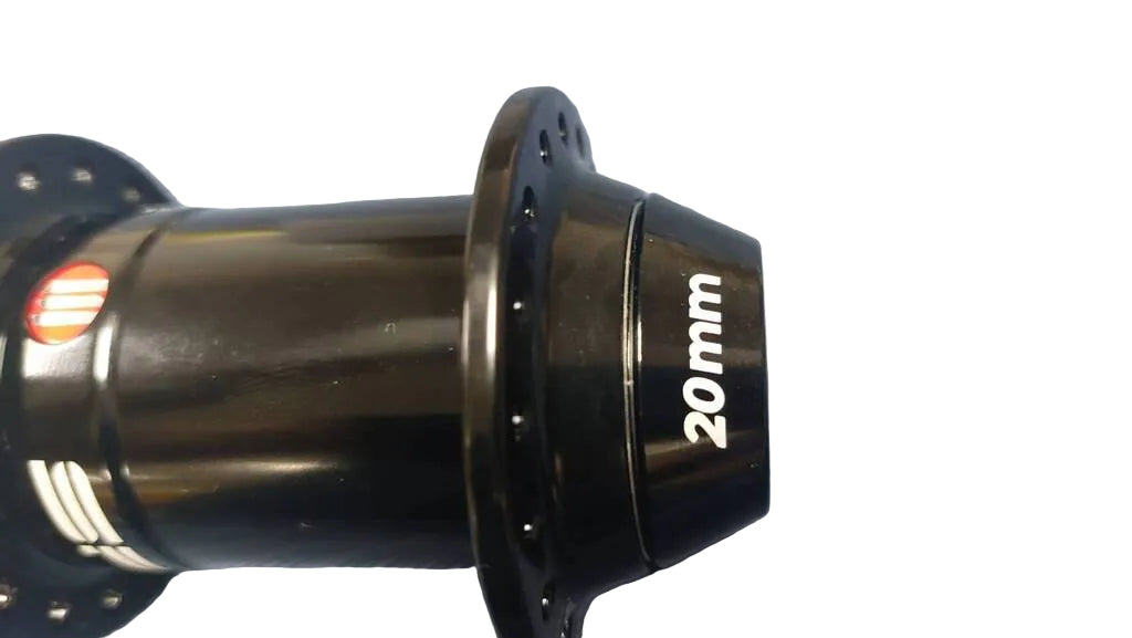 A close-up of a black bicycle hub with '20mm' printed in white on its side.