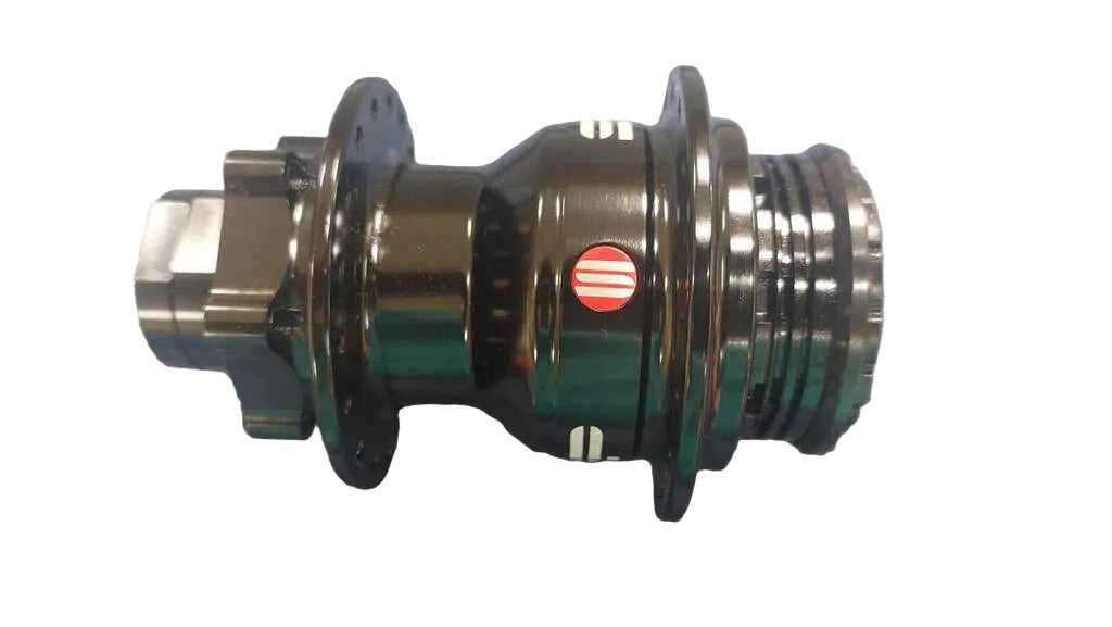 A close-up of a bicycle hub component with a dark metallic finish, featuring a small red and white striped logo on the side.