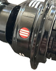 Close-up of a black bicycle wheel hub with a red and white circular logo sticker.