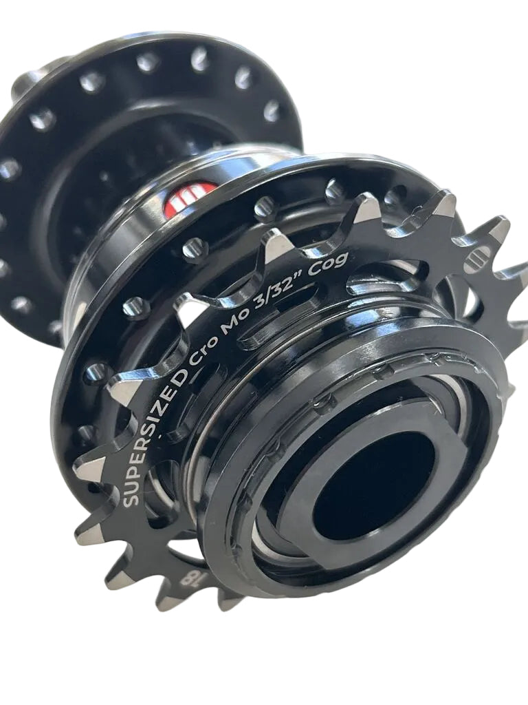Close-up of a black bicycle hub with visible text reading 'SUPER SIZED Cro Mo 3/32" Cog' on the side.